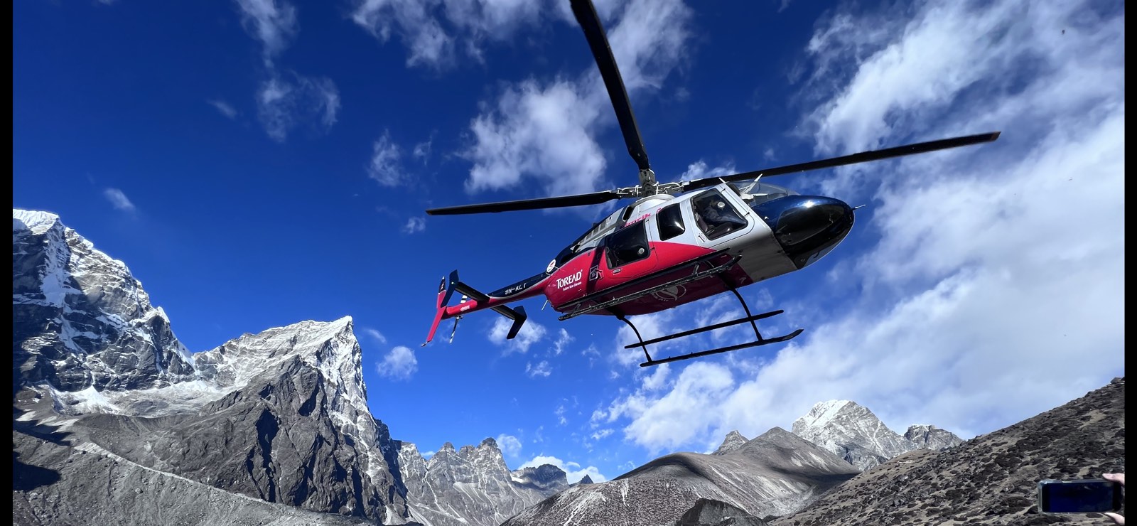 Reaching New Heights: A breathtaking view of a helicopter soaring near Mount Everest 